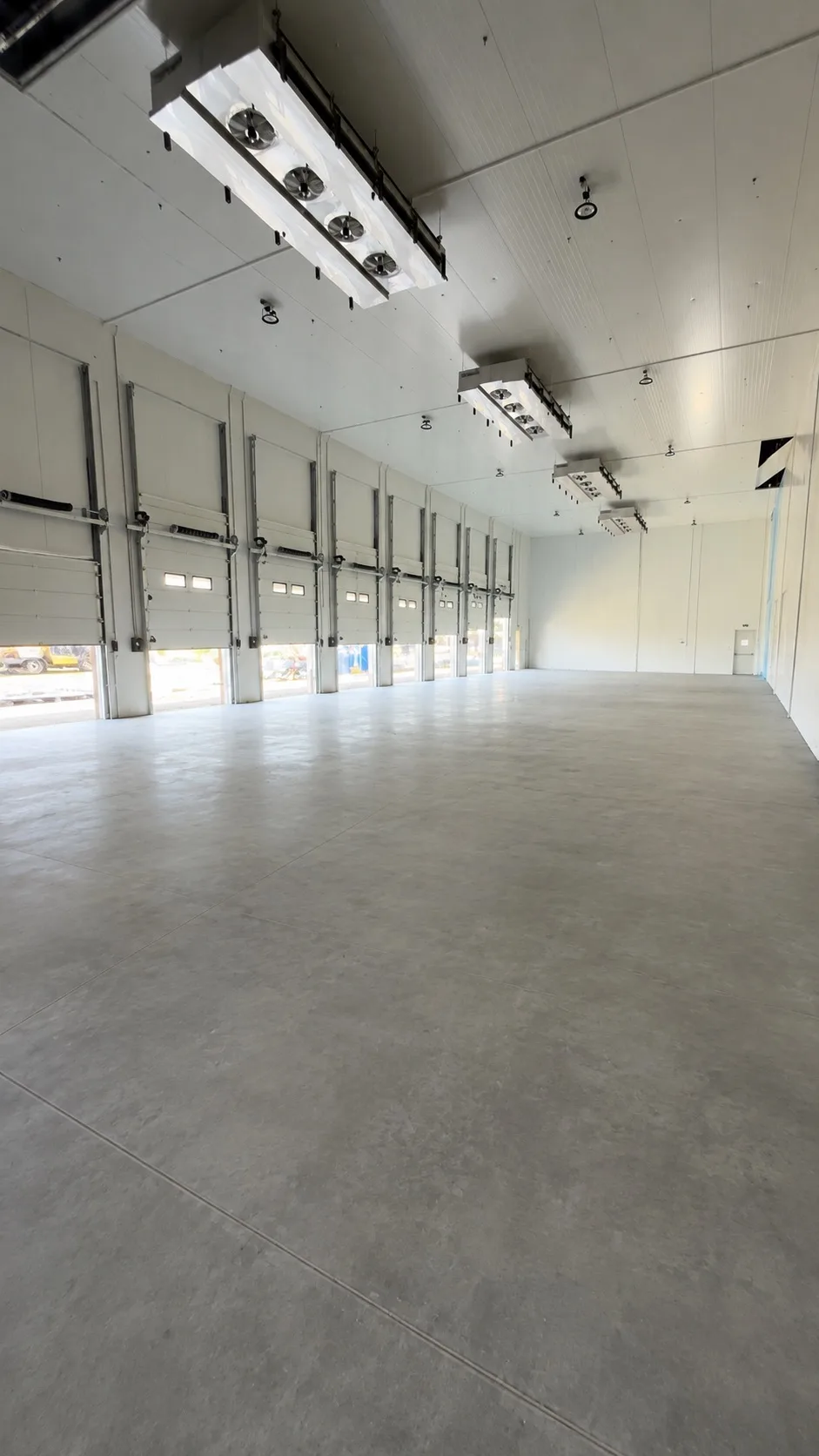 Finished commercial loading area with installed overhead and personnel doors