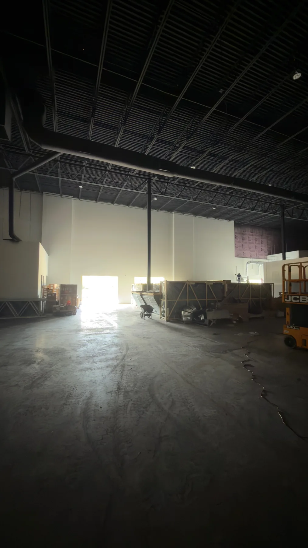Large commercial interior with completed white wall finishes and dark ceiling